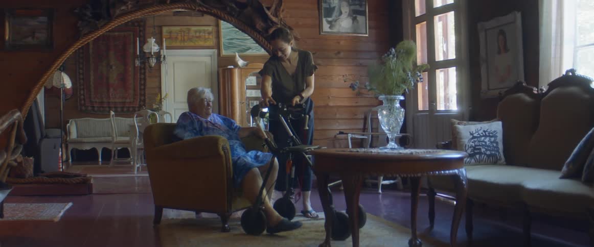 A daughter helping her elderly mother get up