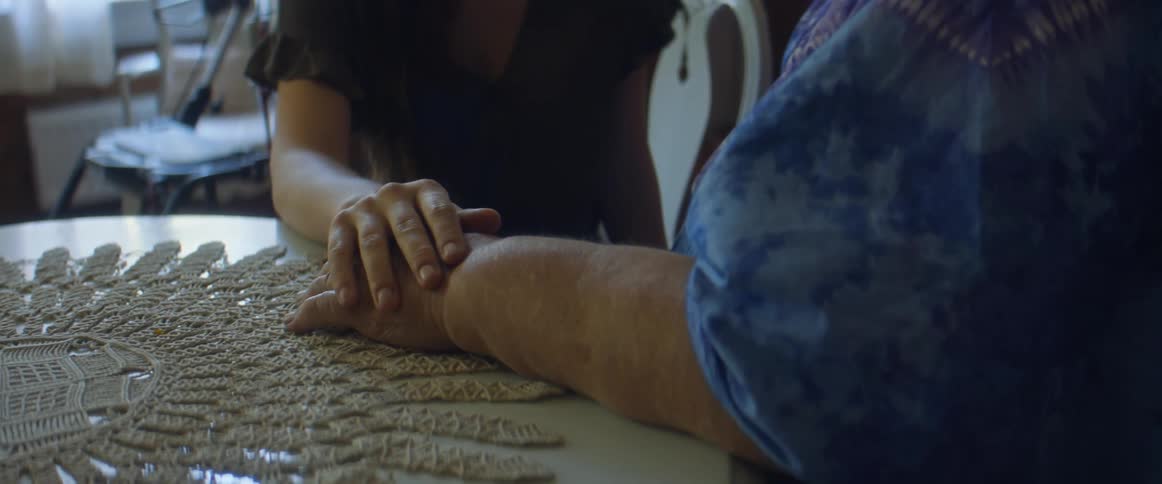 A woman puts her hand on another womans hand