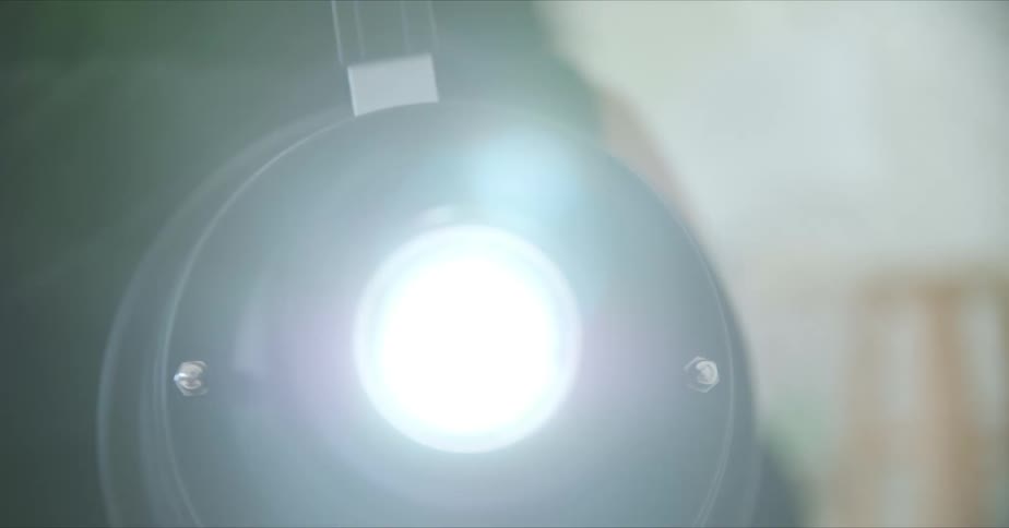A bright camera flash comes on as a photographer shoots in a studio