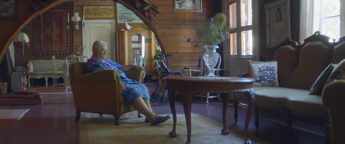 An elderly woman sitting alone in a house