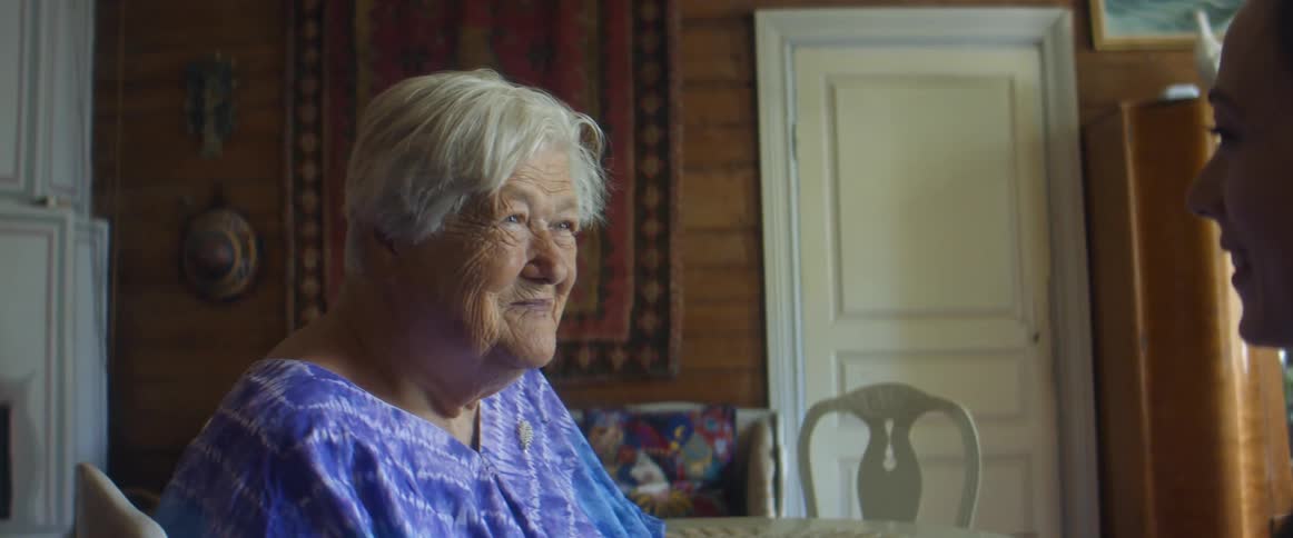 A woman sits and talks with an elderly woman