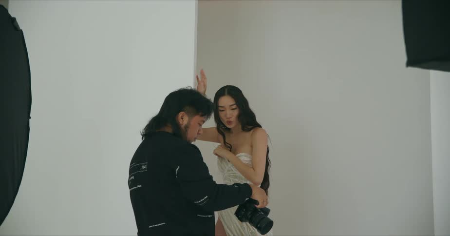 Photographer showing pictures on the camera to a model inside a studio