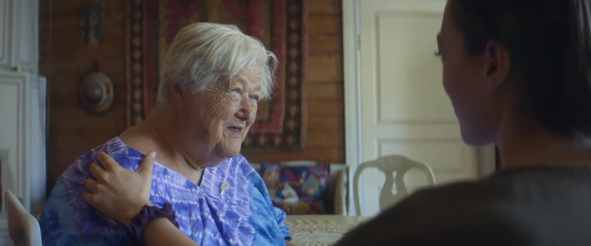 A elderly woman sitting with a younger woman