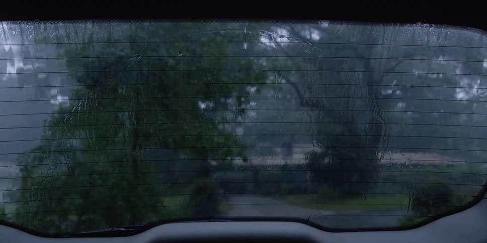 Close up of rain falling on a cars windshield and wiper cleaning it away
