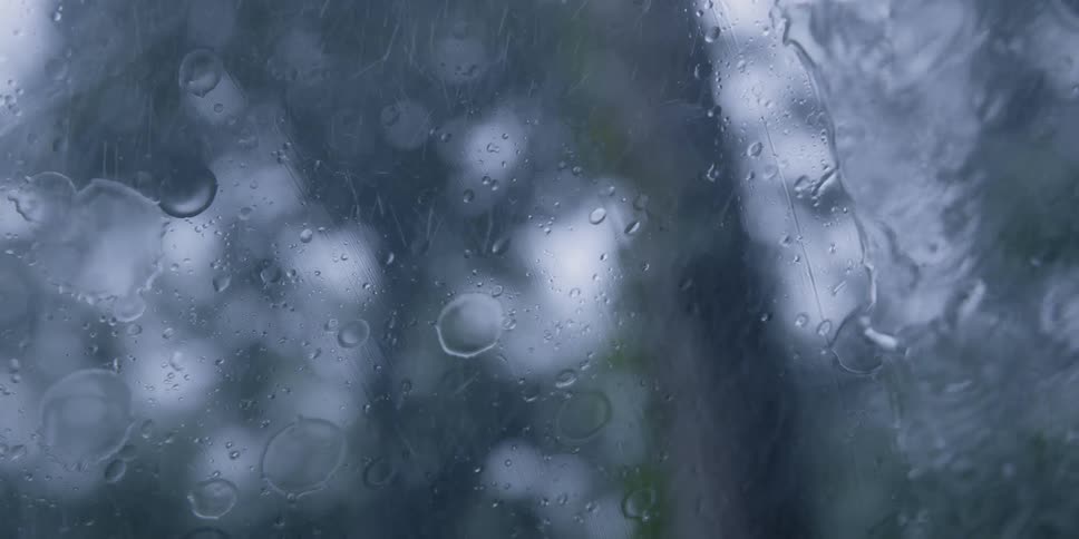 A windshield wiper cleans rain from a windshield during a downpour