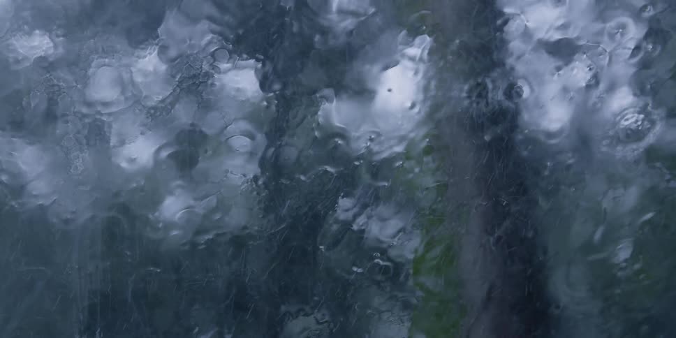 Rain running down a windshield is periodically wiped away by a windshield wiper