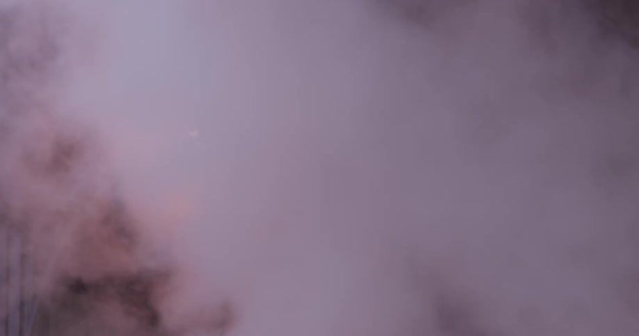 Smoke rises past a lamp post