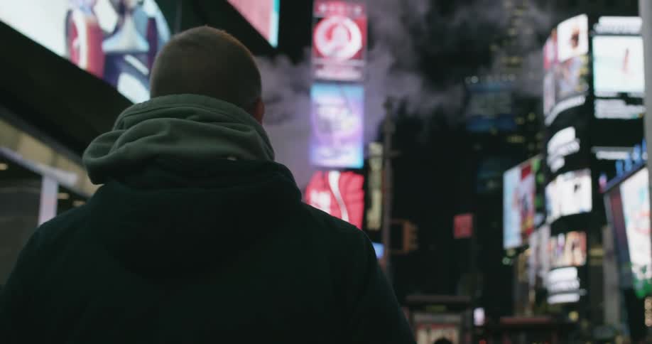 Man walks below lots of advertisements