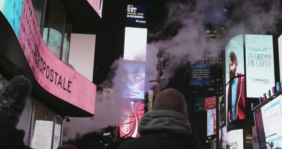 Man walks down street with many advertisements shown on buildings