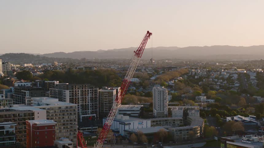 Red and white construction crane on a construction site in the city