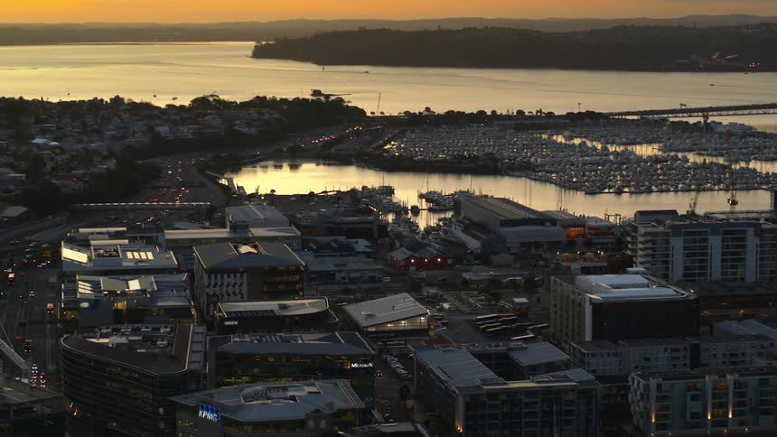 A city sits on the waterfront with boats filling the marina