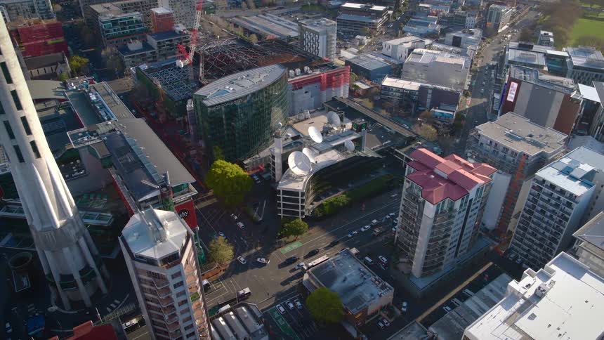 Vehicles travel on the city streets near the tall buildings