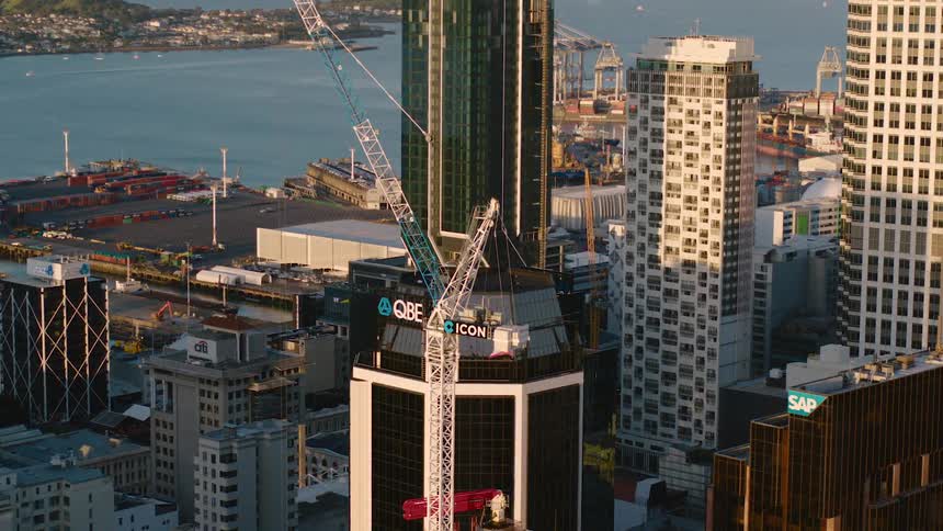 A city skyline with buildings skyscrapers and construction cranes with the sky and clouds in the background