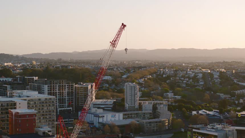 Construction crane sits in the city near the apartment buildings