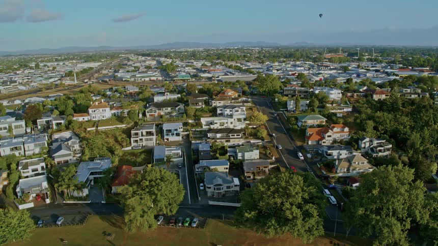 A hot air balloon flies over a neighborhood of luxury homes