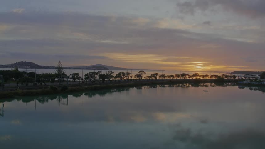 Aerial view of still lake next to road at dusk
