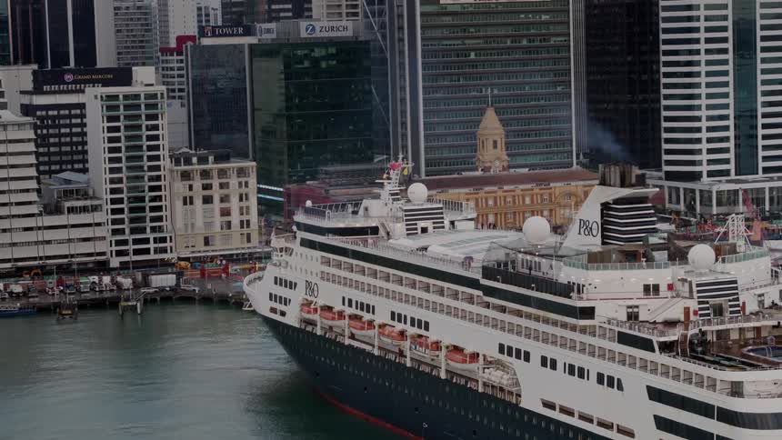 A po cruise ship is docked at a city wharf