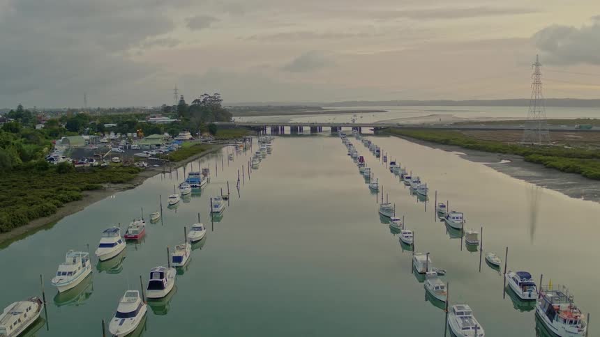 Rows of boats on a river in a rural area in the evening