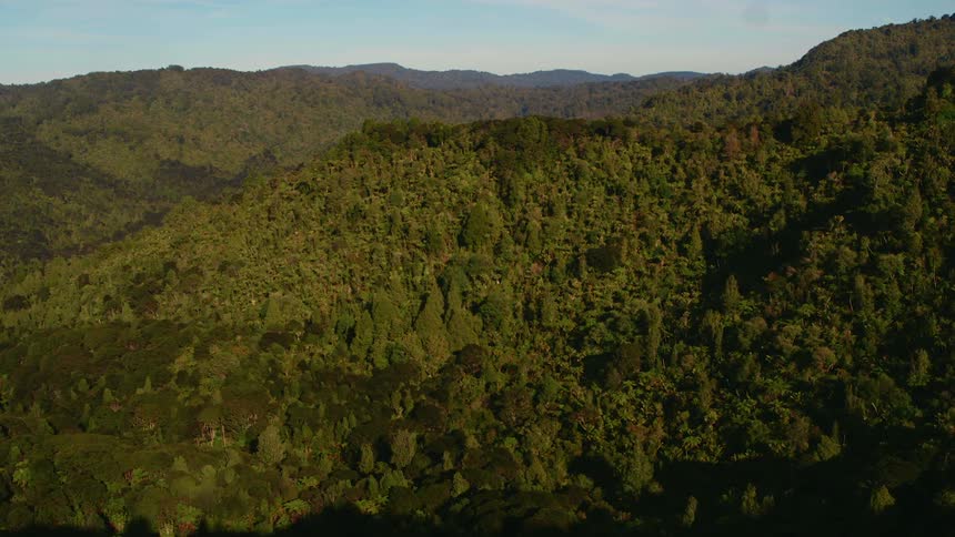 A landscape with hills and trees with the sky and clouds in the background
