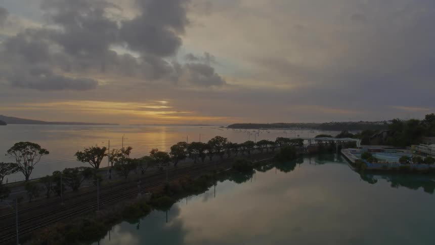 Aerial view of still lake and road at sunset