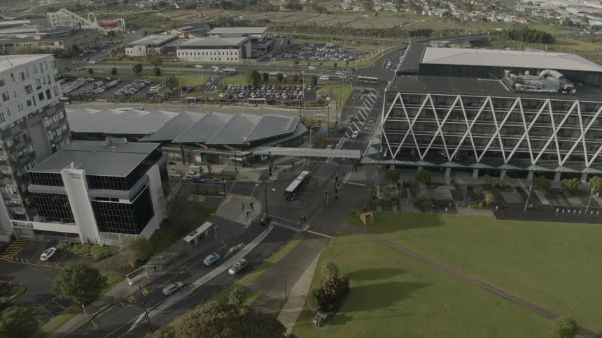 Multiple vehicles travel the roads around large buildings