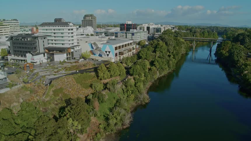 Aerial view of still river next to city buildings