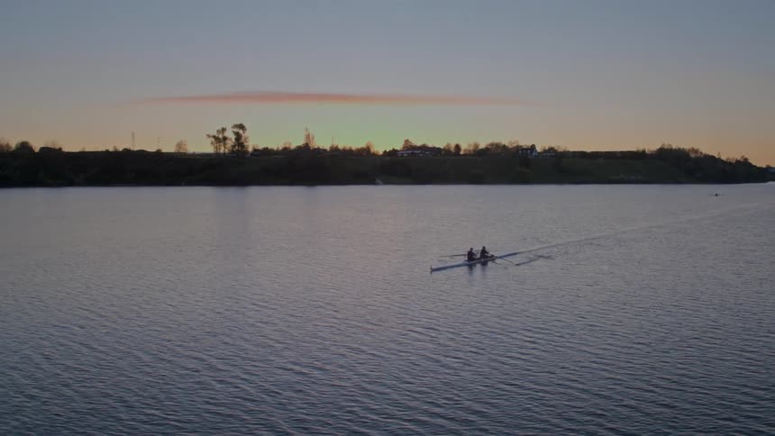 An aerial view of two people rowing a boat