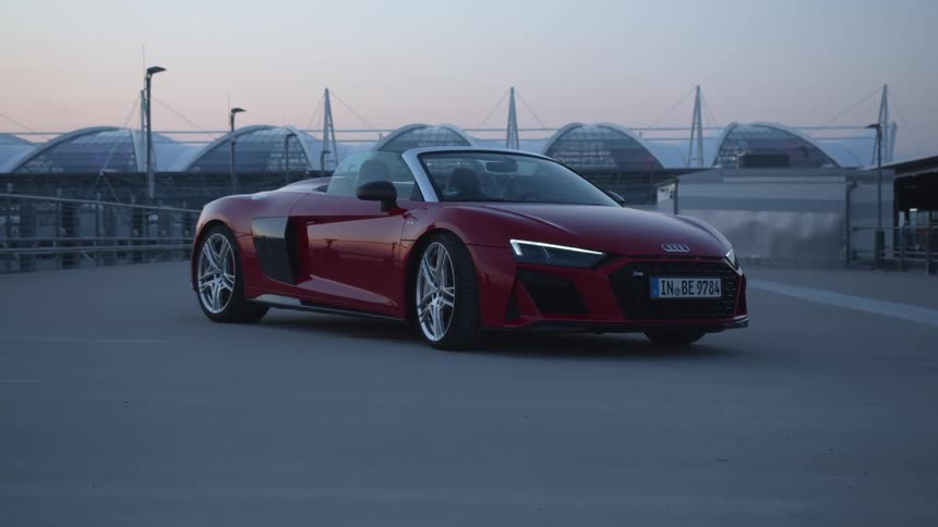 A sports car parked on a boardwalk at sunset