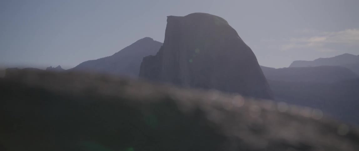 A rock glimmers under bright sunlight over a canyon