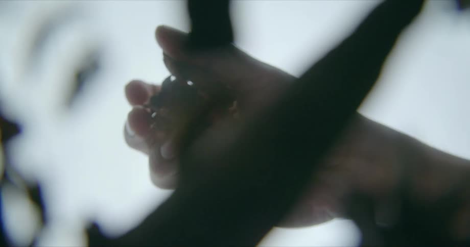 A person in a room with debris in their hand and dropping it