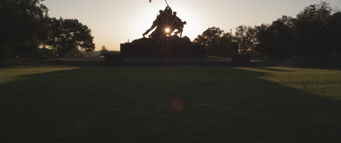 View of a large statue with the sun rising behind it