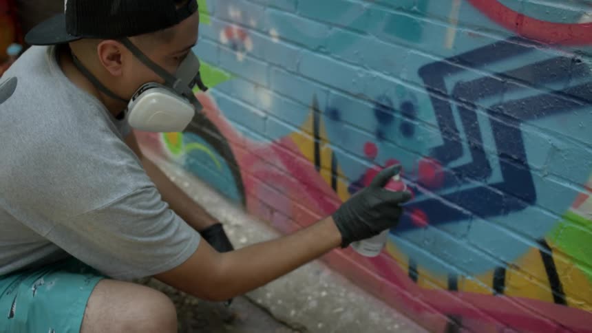 A man spray paints a wall