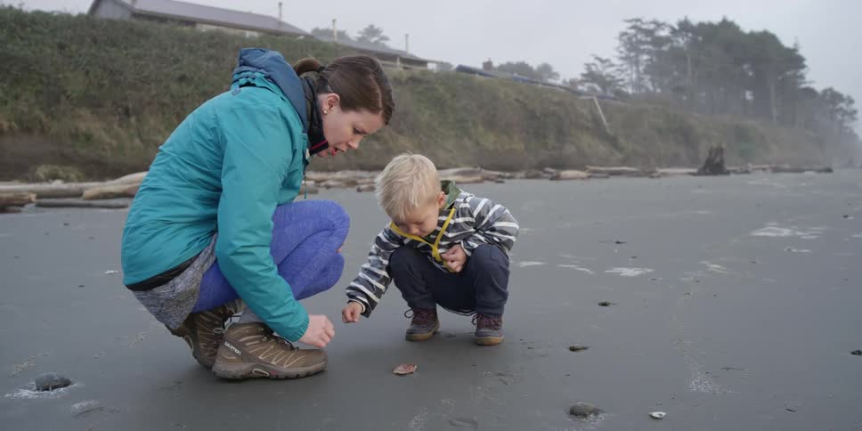 A woman and child examine things on the ground