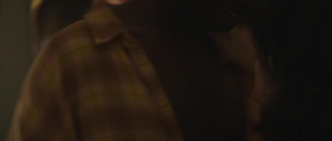 A teenage boy and girl dance closely together as other dance around them in flashing lights