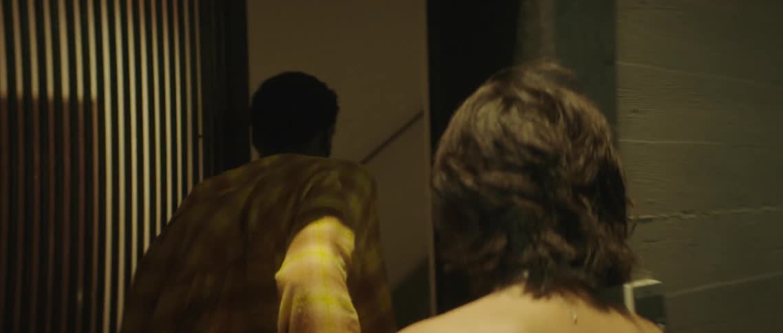 A man and woman running into a building and up the stairs