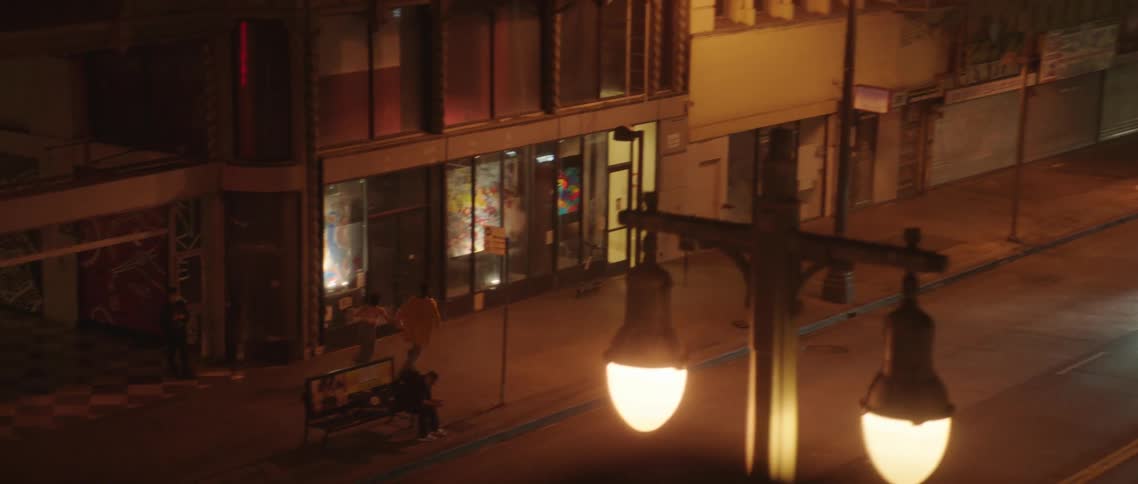 Young couple running on the street of a city holding hands at night