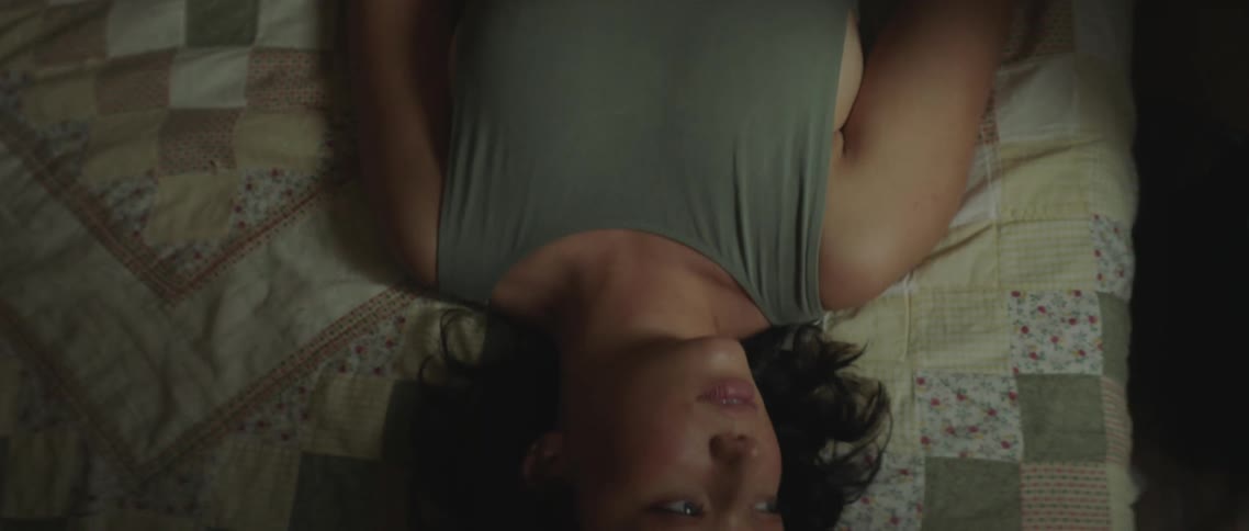 A teenage girl lies in a bed resting
