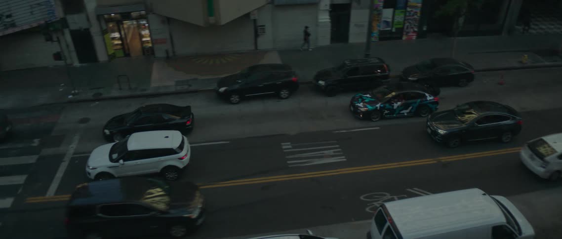 A view of cars driving down a road on a street
