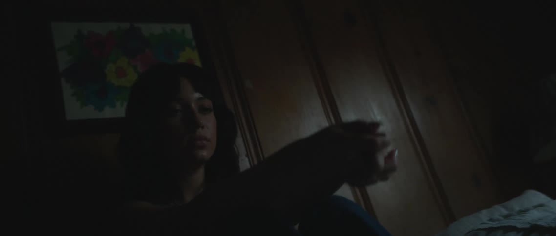 A woman is sitting in her bed at night