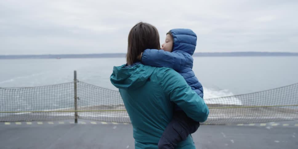 A child hugs a woman as he is being held