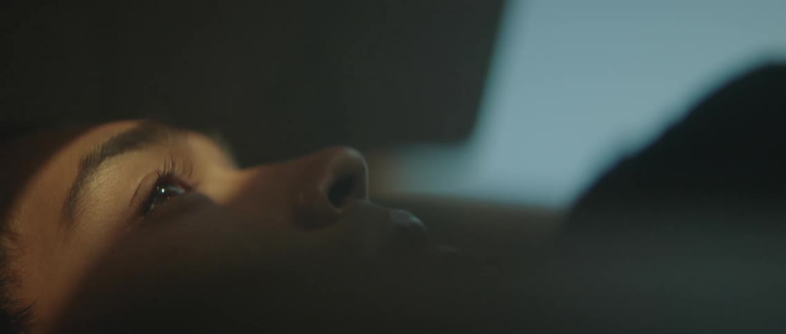 Close up of a young man laying on the back seat of a car at sunset