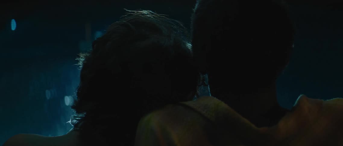 A woman leans her head on a mans shoulder as they look up at the night sky