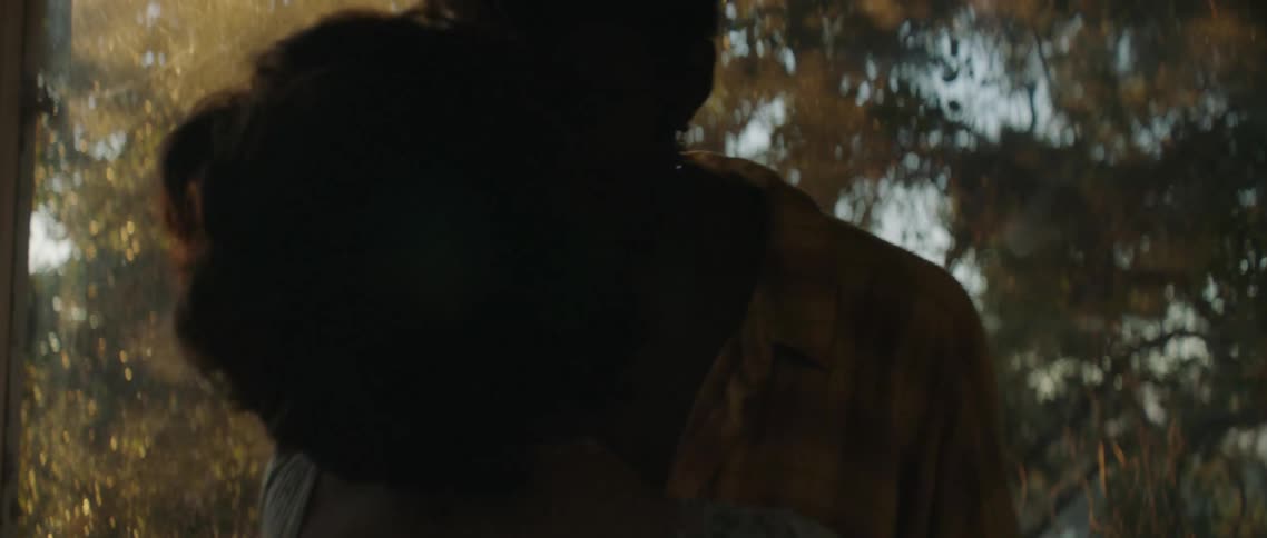 A man and a woman embrace in a kiss