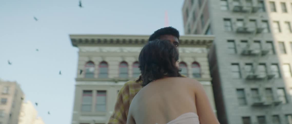 A couple watch a flock of birds on the roof