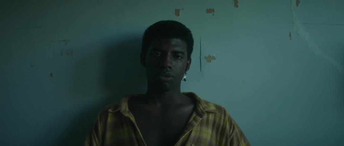 A man sitting in a room on a bed