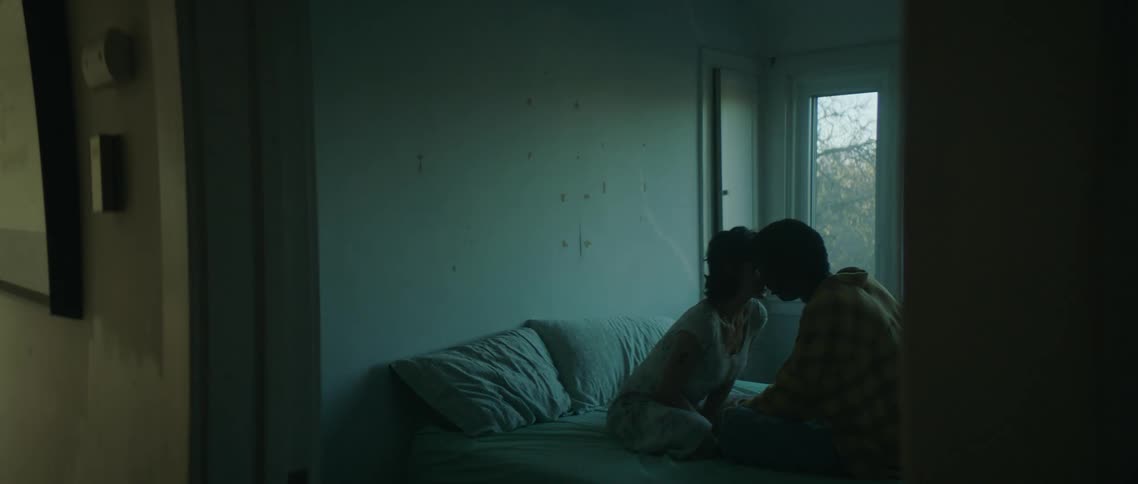 A man and woman kissing in a room