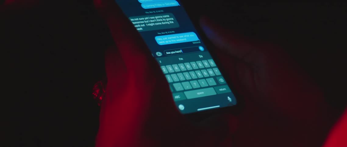 Person texts on mobile phone colored by colored lighting