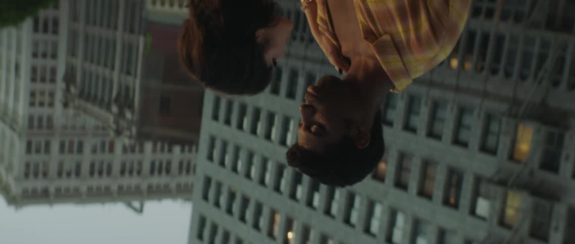 A man and woman kiss on the roof top