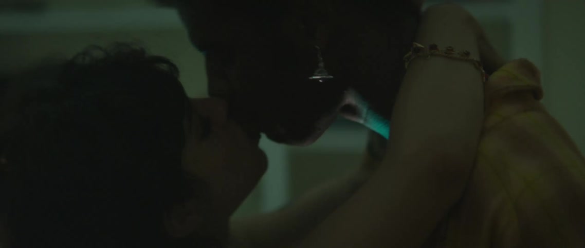A boyfriend and girlfriend kissing at a party