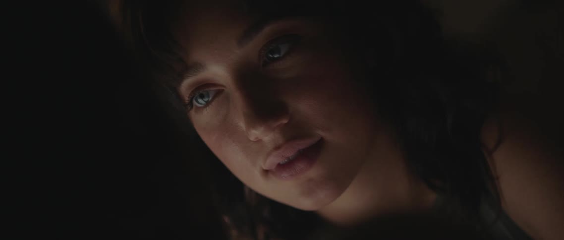A woman with light blue eyes stares into the eyes of a man